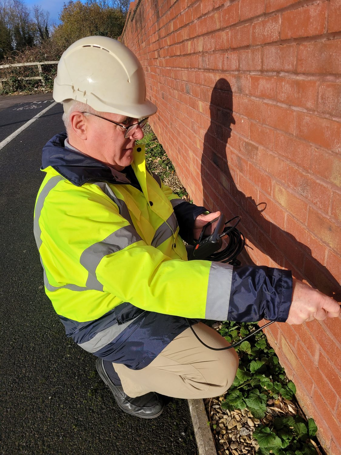 Stephen Thomas carrying out a close inspection of an external wall with specialist equipment